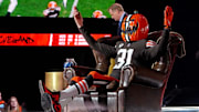 A Cleveland Browns fan in a pumpkin head sits on the commissioners chair during the 2021 NFL Draft at First Energy Stadium. 