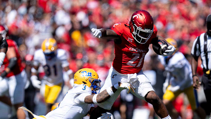 Cincinnati Bearcats running back Corey Kiner (21) breaks a tackle attempt by Pittsburgh Panthers defensive back Donovan McMillon (3) in the third quarter of the College Football game at Nippert Stadium in Cincinnati on Saturday, Sept. 7, 2024.