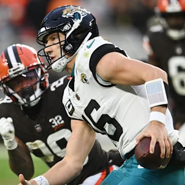 Dec 10, 2023; Cleveland, Ohio, USA; Jacksonville Jaguars quarterback Trevor Lawrence (16) scrambles from Cleveland Browns cornerback Cameron Mitchell (29) during the second half at Cleveland Browns Stadium. Mandatory Credit: Ken Blaze-Imagn Images