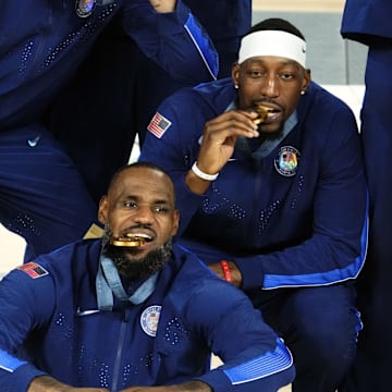 Aug 10, 2024; Paris, France; United States guard LeBron James (6) and centre Bam Adebayo (13) celebrate with their gold medals after defeating France in the men's basketball gold medal game during the Paris 2024 Olympic Summer Games at Accor Arena. Mandatory Credit: Rob Schumacher-Imagn Images