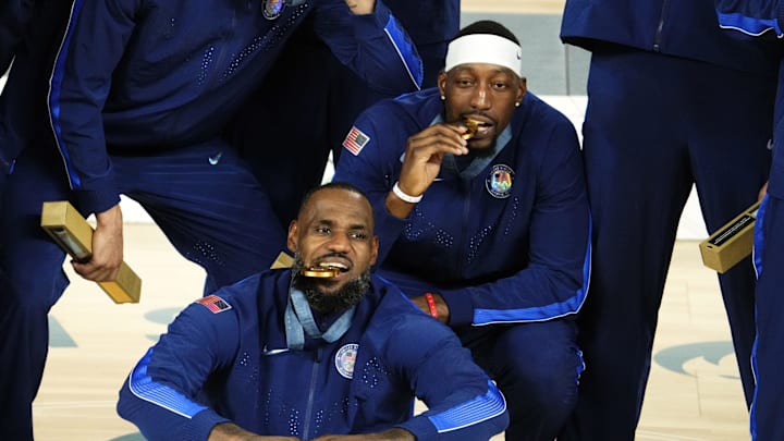 Aug 10, 2024; Paris, France; United States guard LeBron James (6) and centre Bam Adebayo (13) celebrate with their gold medals after defeating France in the men's basketball gold medal game during the Paris 2024 Olympic Summer Games at Accor Arena. Mandatory Credit: Rob Schumacher-Imagn Images