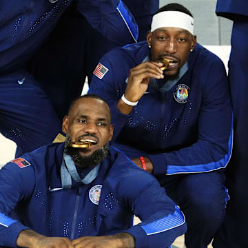Aug 10, 2024; Paris, France; United States guard LeBron James (6) and centre Bam Adebayo (13) celebrate with their gold medals after defeating France in the men's basketball gold medal game during the Paris 2024 Olympic Summer Games at Accor Arena. Mandatory Credit: Rob Schumacher-Imagn Images