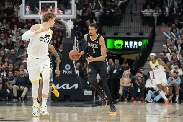 San Antonio Spurs center Victor Wembanyama (1) dribbles the ball behind Utah Jazz forward Lauri Markkanen (23). 