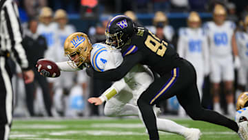 Nov 15, 2024; Seattle, Washington, USA; Washington Huskies defensive lineman Russell Davis II (99) sacks UCLA Bruins quarterback Ethan Garbers (4) during the second half at Alaska Airlines Field at Husky Stadium. Mandatory Credit: Steven Bisig-Imagn Images