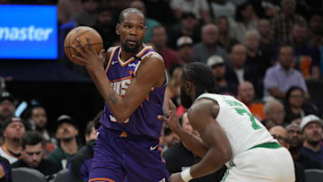 Mar 26, 2025; Phoenix, Arizona, USA; Phoenix Suns forward Kevin Durant (35) shields the ball from Boston Celtics guard Jaylen Brown (7) during the first half at Footprint Center. Mandatory Credit: Rick Scuteri-Imagn Images