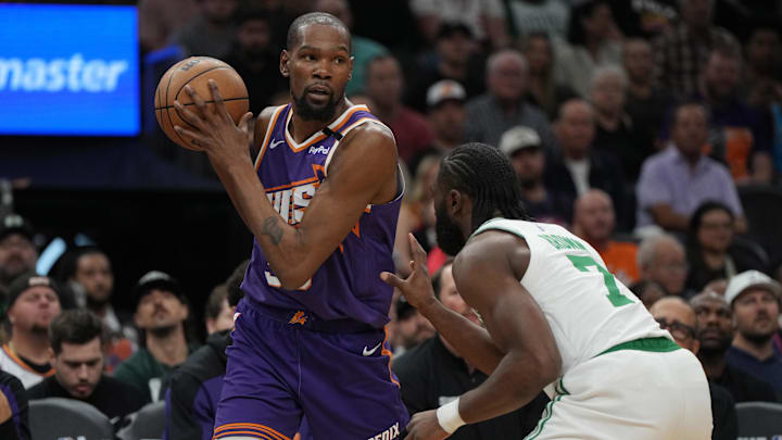 Mar 26, 2025; Phoenix, Arizona, USA: Phoenix Suns forward Kevin Durant (35) shields the ball from Boston Celtics guard Jaylen Brown (7) during the first half at Footprint Center. Mandatory Credit: Rick Scuteri-Imagn Images
