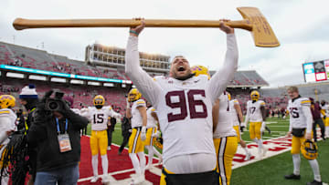 Nov 29, 2024; Madison, Wisconsin, USA;  Minnesota Golden Gophers defensive lineman Logan Richter (96) celebrates with the Paul Bunyan Football Trophy following the game against the Wisconsin Badgers at Camp Randall Stadium.