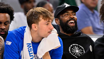 Oct 6, 2025; Fort Worth, Texas, USA; Dallas Mavericks forward Cooper Flagg (left) and guard Kyrie Irving (right) look on during the game between the Dallas Mavericks and the Oklahoma City Thunder at Dickie's Arena. Mandatory Credit: Jerome Miron-Imagn Images