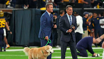 Jan 8, 2024; Houston, TX, USA; ESPN analyst  Kirk Herbstreit walks his dog Ben with ESPN host Chris Fowler before the 2024 College Football Playoff national championship game between the Michigan Wolverines and the Washington Huskies at NRG Stadium. Mandatory Credit: Kirby Lee-Imagn Images