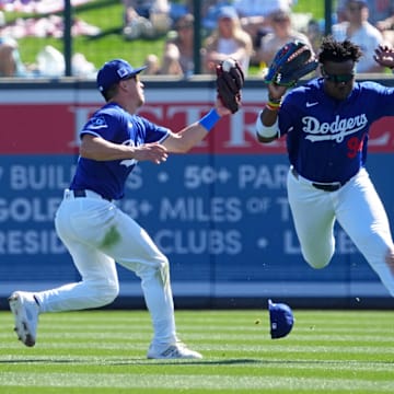 Feb 23, 2025; Phoenix, Arizona, USA; Los Angeles Dodgers outfielder Tommy Edman (25) makes a catch on a pop-up while avoiding teammate right fielder Zyhir Hope (94) during the third inning at Camelback Ranch-Glendale. Mandatory Credit: Joe Camporeale-Imagn Images
