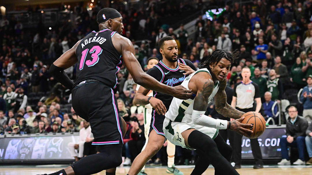 Feb 24, 2026; Milwaukee, Wisconsin, USA;  Milwaukee Bucks guard Kevin Porter (7) gets pressure from Miami Heat guard Norman Powell (24) and forward Bam Adebayo (13) in the fourth quarter at Fiserv Forum. Mandatory Credit: Benny Sieu-Imagn Images