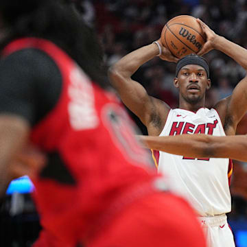 Apr 12, 2024; Miami, Florida, USA;  Miami Heat forward Jimmy Butler (22) looks to pass the ball as Toronto Raptors guard Ochai Agbaji (30) defends during the first half at Kaseya Center. Mandatory Credit: Jim Rassol-Imagn Images