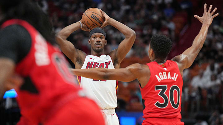 Apr 12, 2024; Miami, Florida, USA;  Miami Heat forward Jimmy Butler (22) looks to pass the ball as Toronto Raptors guard Ochai Agbaji (30) defends during the first half at Kaseya Center. Mandatory Credit: Jim Rassol-Imagn Images