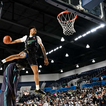 Apr 1, 2024; Houston, TX, USA; McDonalds High School All American guard Jalil Bethea (1) jumps over seven foot two center J.Bol (7) and dunks the ball during the dunk competition in the 2024 McDonalds High School All American Powerade Jam Fest at Delmar Fieldhouse.