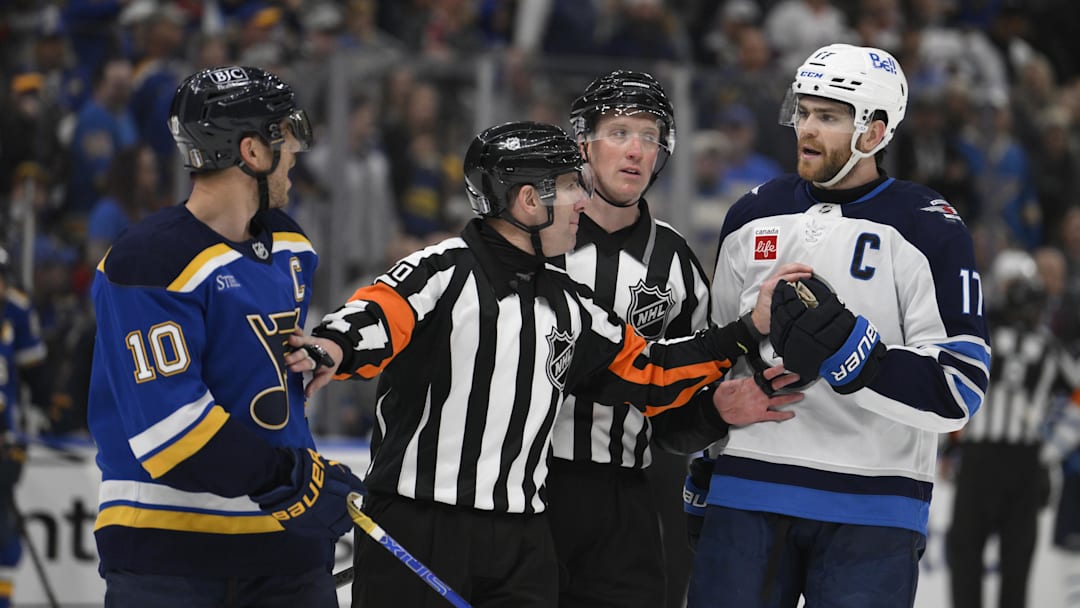 Apr 27, 2025; St. Louis, Missouri, USA; St. Louis Blues center Brayden Schenn (10) talks to Winnipeg Jets center Adam Lowry (17) during the third period in game four of the first round of the 2025 Stanley Cup Playoffs at Enterprise Center. Mandatory Credit: Jeff Le-Imagn Images