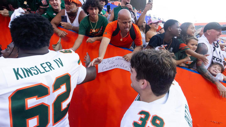 Miami fans shake hands with Miami Hurricanes offensive lineman Tommy Kinsler IV (62) and Miami Hurricanes linebacker Casey Rizzi (39) during the season opener at Ben Hill Griffin Stadium in Gainesville, FL on Saturday, August 31, 2024 against the University of Miami Hurricanes. The Hurricanes defeated the Gators 41-17. [Doug Engle/Gainesville Sun]