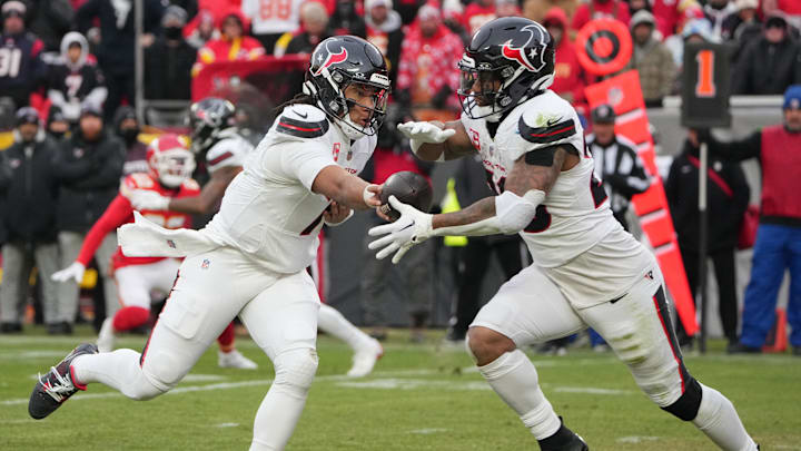 Jan 18, 2025; Kansas City, Missouri, USA; Houston Texans quarterback C.J. Stroud (7) hands off the ball to running back Joe Mixon (28) against the Kansas City Chiefs during the second quarter of a 2025 AFC divisional round game at GEHA Field at Arrowhead Stadium. Mandatory Credit: Denny Medley-Imagn Images