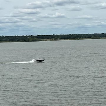A boat races across Grapevine Lake where Ava Moore, 18, a 2024 graduate of Fort Worth Timber Creek and an Air Force basketball commit, was fatally struck by a jet ski while kayaking on Sunday. The driver of the jet ski fled the area with another male before authorities arrived. Grapevine PD and Texas Park and Wildlife are investigating and are asking for the public's help in identifying both suspects.