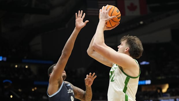 Oregon Ducks center Nate Bittle (32) shoots the ball over Liberty Flames forward Owen Aquino (8) during the first half