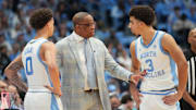 Dec 7, 2025; Chapel Hill, North Carolina, USA; North Carolina Tar Heels head coach Hubert Davis talks with guard Kyan Evans (0) and guard Derek Dixon (3) in the second half at Dean E. Smith Center. Mandatory Credit: Bob Donnan-Imagn Images