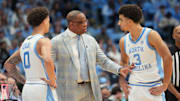 Dec 7, 2025; Chapel Hill, North Carolina, USA; North Carolina Tar Heels head coach Hubert Davis talks with guard Kyan Evans (0) and guard Derek Dixon (3) in the second half at Dean E. Smith Center. Mandatory Credit: Bob Donnan-Imagn Images