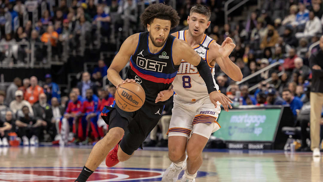 Jan 18, 2025; Detroit, Michigan, USA; Detroit Pistons guard Cade Cunningham (2) moves the ball up court next to Phoenix Suns guard Grayson Allen (8) during the second quarter at Little Caesars Arena. Mandatory Credit: David Reginek-Imagn Images