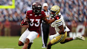 Oct 26, 2024; Blacksburg, Virginia, USA; Virginia Tech Hokies running back Bhayshul Tuten (33) runs the ball against Georgia Tech Yellow Jackets defensive back Clayton Powell-Lee (5) during the second quarter at Lane Stadium. Mandatory Credit: Peter Casey-Imagn Images