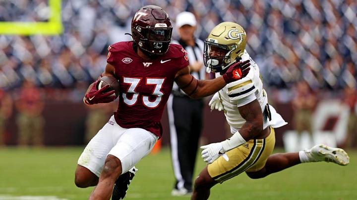 Oct 26, 2024; Blacksburg, Virginia, USA; Virginia Tech Hokies running back Bhayshul Tuten (33) runs the ball against Georgia Tech Yellow Jackets defensive back Clayton Powell-Lee (5) during the second quarter at Lane Stadium. Mandatory Credit: Peter Casey-Imagn Images