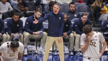 Dec 3, 2025; Morgantown, West Virginia, USA; West Virginia Mountaineers head coach Ross Hodge talks to his players during the first half against the Coppin State Eagles at Hope Coliseum. Mandatory Credit: Ben Queen-Imagn Images