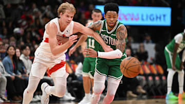 Oct 10, 2025; Toronto, Ontario, CAN;  Toronto Raptors forward Gradey Dick (1) knocks the ball away from Boston Celtics guard Anfernee Simons (4) in the second half at Scotiabank Arena. Mandatory Credit: Dan Hamilton-Imagn Images