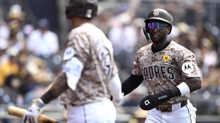 Jun 23, 2024; San Diego, California, USA; San Diego Padres left fielder Jurickson Profar (right) is greeted at home after scoring a run on a sacrifice fly by third baseman Manny Machado (left) during the eighth inning at Petco Park. Mandatory Credit: Orlando Ramirez-USA TODAY Sports