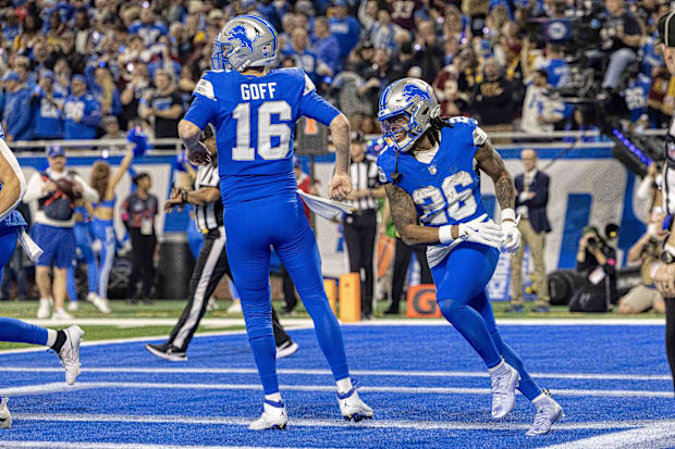 Detroit Lions running back Jahmyr Gibbs celebrates a touchdown with quarterback Jared Goff