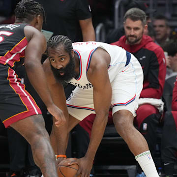 Mar 12, 2025; Miami, Florida, USA;  LA Clippers guard James Harden (1) looks to pass against Miami Heat guard Davion Mitchell (45) defends during the first half at Kaseya Center. Mandatory Credit: Jim Rassol-Imagn Images