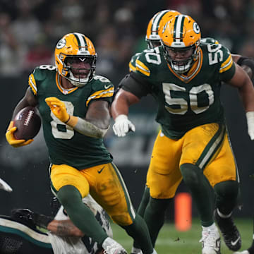 Right tackle Zach Tom leads Packers running back Josh Jacobs into the open field against the Eagles.