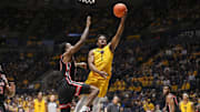 Jan 29, 2025; Morgantown, West Virginia, USA; West Virginia Mountaineers guard Joseph Yesufu (1) shoots against Houston Cougars guard Terrance Arceneaux (23) during the first half at WVU Coliseum. Mandatory Credit: Ben Queen-Imagn Images