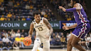 Feb 25, 2025; Morgantown, West Virginia, USA; West Virginia Mountaineers forward Amani Hansberry (13) drives against TCU Horned Frogs center Ernest Udeh Jr. (8) during the first half at WVU Coliseum. Mandatory Credit: Ben Queen-Imagn Images