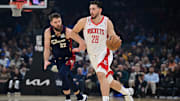 Nov 19, 2025; Cleveland, Ohio, USA; Houston Rockets center Alperen Sengun (28) dribbles ahead of Cleveland Cavaliers forward Dean Wade (32) during the first half at Rocket Arena. Mandatory Credit: David Dermer-Imagn Images
