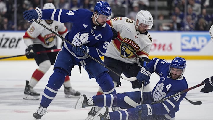 May 14, 2025; Toronto, Ontario, CAN; Toronto Maple Leafs forward Auston Matthews (34) and forward John Tavares (91)  and Florida Panthers forward Brad Marchand (63) battle for a puck during the second period of game five of the second round of the 2025 Stanley Cup Playoffs at Scotiabank Arena. Mandatory Credit: John E. Sokolowski-Imagn Images