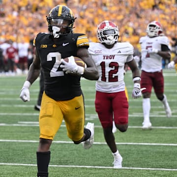 Sep 14, 2024; Iowa City, Iowa, USA; Iowa Hawkeyes running back Kaleb Johnson (2) scores on a 33 yard run as Troy Trojans cornerback Trent Henry (12) and safety Ian Conerly-Goodly (39) pursue during the fourth quarter at Kinnick Stadium. Mandatory Credit: Jeffrey Becker-Imagn Images