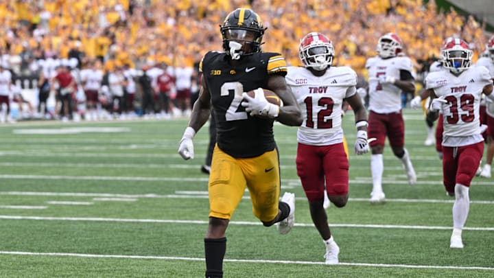 Sep 14, 2024; Iowa City, Iowa, USA; Iowa Hawkeyes running back Kaleb Johnson (2) scores on a 33 yard run as Troy Trojans cornerback Trent Henry (12) and safety Ian Conerly-Goodly (39) pursue during the fourth quarter at Kinnick Stadium. Mandatory Credit: Jeffrey Becker-Imagn Images