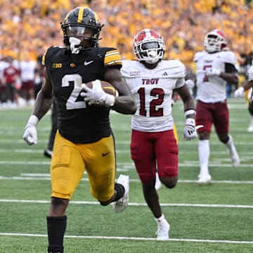 Sep 14, 2024; Iowa City, Iowa, USA; Iowa Hawkeyes running back Kaleb Johnson (2) scores on a 33 yard run as Troy Trojans cornerback Trent Henry (12) and safety Ian Conerly-Goodly (39) pursue during the fourth quarter at Kinnick Stadium. Mandatory Credit: Jeffrey Becker-Imagn Images