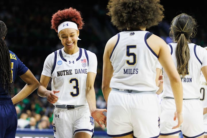 Notre Dame guard Hannah Hidalgo slaps hands with guard Olivia Miles during a game against Michigan.