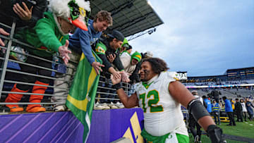 Mimi Duck and the rest of Oregon's biggest fans line up to exchange a high five with all-conference center Poncho Laloulu's hand after the Ducks locked up their home playoff game with a win in Husky Stadium.