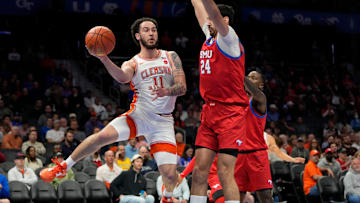 Mar 13, 2025; Charlotte, NC, USA; Clemson Tigers guard Jaeden Zackery (11) passes the ball as Southern Methodist Mustangs center Samet Yigitoglu (24) defends in the first half at Spectrum Center. Mandatory Credit: Bob Donnan-Imagn Images