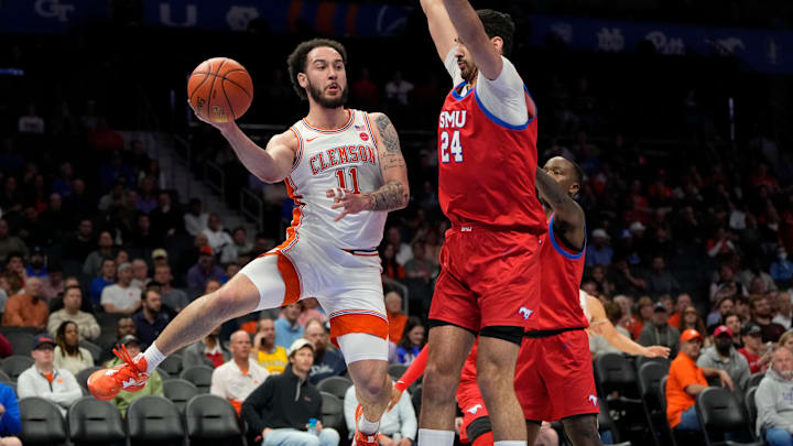 Mar 13, 2025; Charlotte, NC, USA; Clemson Tigers guard Jaeden Zackery (11) passes the ball as Southern Methodist Mustangs center Samet Yigitoglu (24) defends in the first half at Spectrum Center. Mandatory Credit: Bob Donnan-Imagn Images