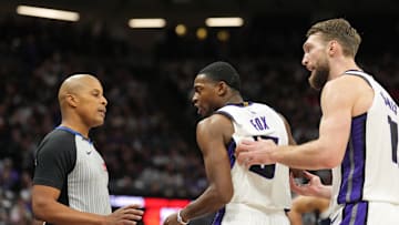 Dec 30, 2024; Sacramento, California, USA; Sacramento Kings guard De'Aaron Fox (center) and forward Domantas Sabonis (right) argue with referee CJ Washington (left) during the third quarter against the Dallas Mavericks at Golden 1 Center. Mandatory Credit: Darren Yamashita-Imagn Images