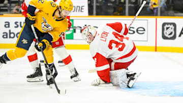 Oct 19, 2024; Nashville, Tennessee, USA;  Detroit Red Wings goaltender Alex Lyon (34) blocks the shot of  Nashville Predators center Tommy Novak (82) during the first period at Bridgestone Arena. Mandatory Credit: Steve Roberts-Imagn Images