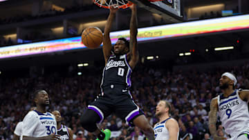 Oct 24, 2024; Sacramento, California, USA; Sacramento Kings guard Malik Monk (0) dunks the ball against Minnesota Timberwolves forward Julius Randle (30) during the second quarter at Golden 1 Center. Mandatory Credit: Sergio Estrada-Imagn Images