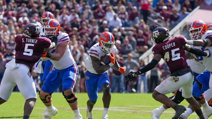 Nov 5, 2022; College Station, Texas, USA; Florida Gators running back Montrell Johnson Jr. (2) runs the ball between Texas A&M Aggies defensive lineman Shemar Turner (5) and linebacker Edgerrin Cooper (45) in the second half at Kyle Field. Mandatory Credit: Daniel Dunn-Imagn Images