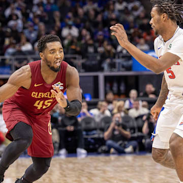 Oct 27, 2025; Detroit, Michigan, USA; Detroit Pistons forward Ronald Holland II (5) defends against Cleveland Cavaliers guard Donovan Mitchell (45) during the second half at Little Caesars Arena. Mandatory Credit: David Reginek-Imagn Images